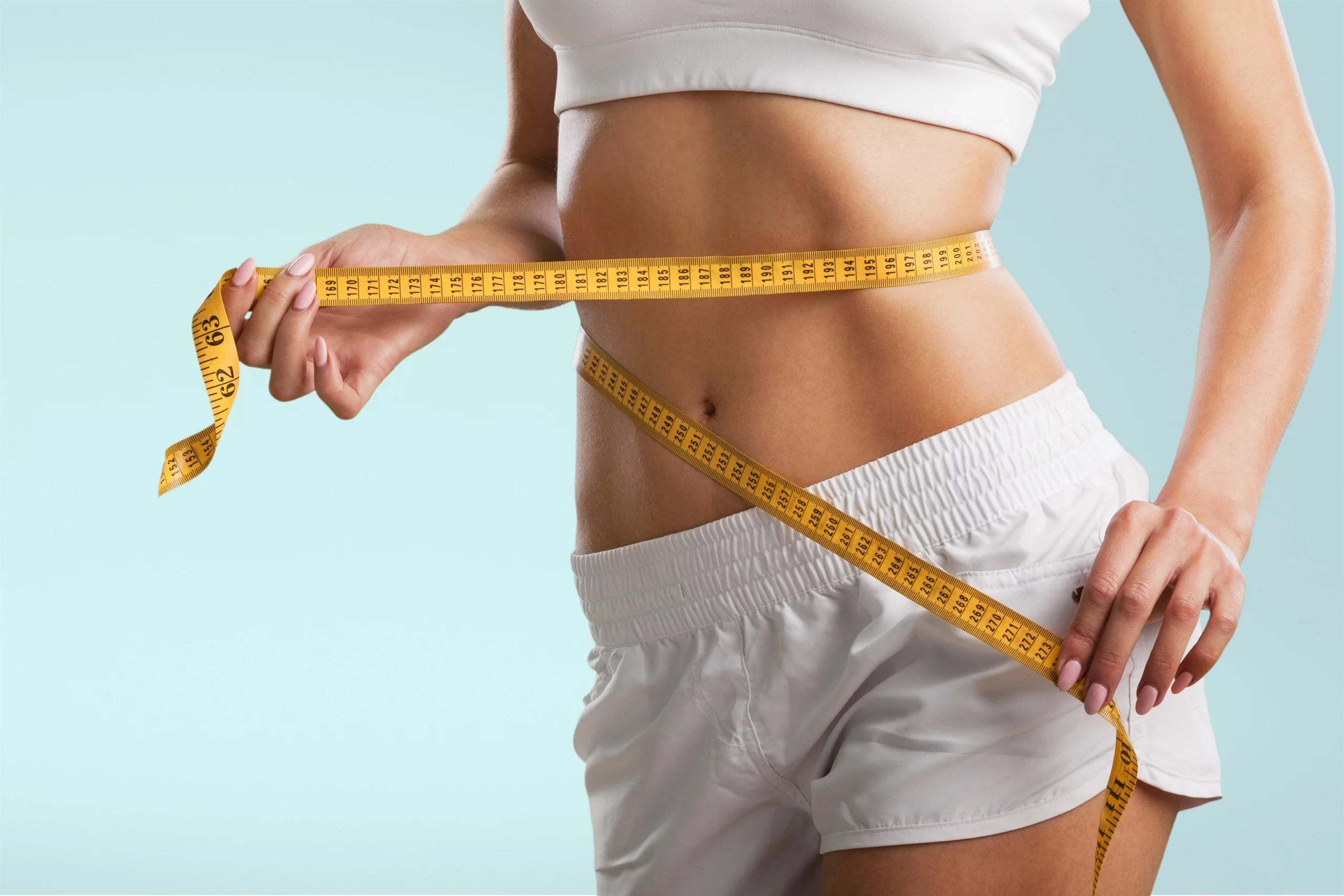 Measuring tape around the waist of a woman
